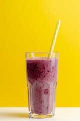 bilberry smoothie in a glass jar on colored background