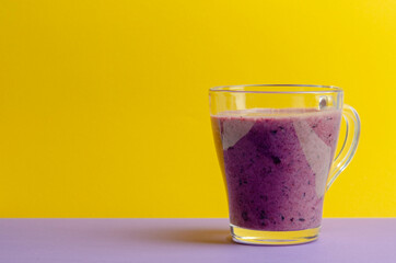 bilberry smoothie in a glass jar on colored background
