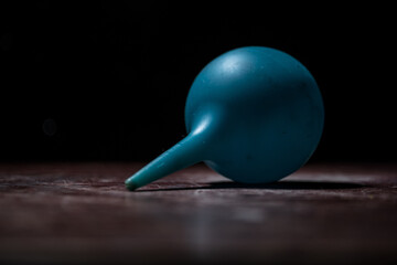 Blue enema on dark background with backlight. Creative artwork decorated with light.