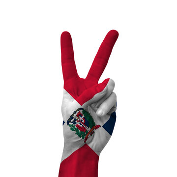 Hand making victory sign, dominican republic painted with flag as symbol of victory, win, success - isolated on white background