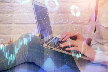 Multi exposure of woman hands typing on computer and forex chart hologram drawing. Stock market...