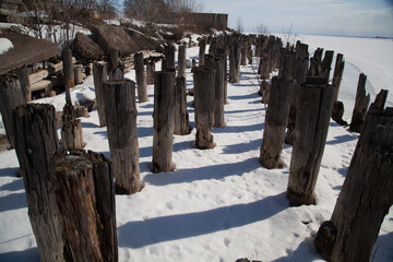 Rotten piles frozen in ice on the old pier