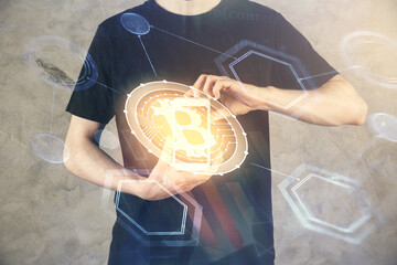 Double exposure of man's hands holding and using a phone and crypto currency blockchain theme...