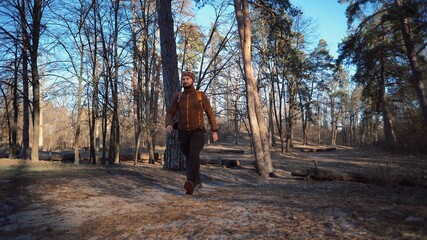 Active male portrait of caucasian sporty man guy hiking outdoors in pine forest. young man tourist...