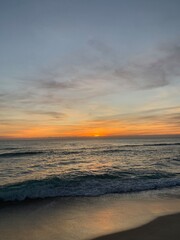 Vibrant sunset over calm sandy beach shoreline