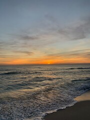 Vibrant sunset over calm sandy beach shoreline