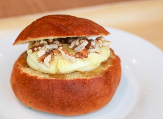 Bread filled with cream cheese and walnuts on a white plate