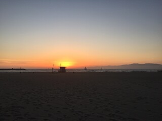 Landscape view of sandy beach sunset with distant coastline at sunset