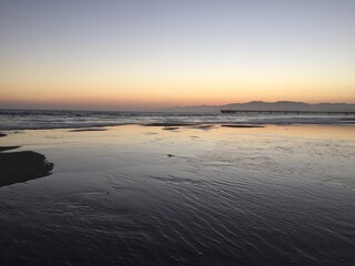 Landscape view of calm beach coast under pastel sunset