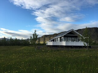 Isolated cabin in mountain terrain valley dandelion field