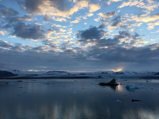 Landscape view of icy lakeside waters near snowcapped mountains