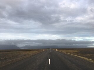 Fototapeta na wymiar Empty road leading to rural cloudy mountains