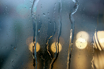 Bokeh in the rain. Water drops on the glass against a bokeh light background