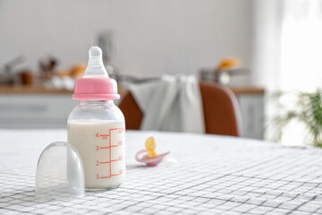 Bottle of milk for baby and pacifier on table - obrazy, fototapety, plakaty