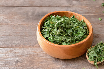 Bowl with dry parsley on table