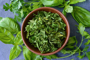 Bowl with dry parsley on dark background