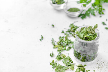 Jar with dry parsley on white background