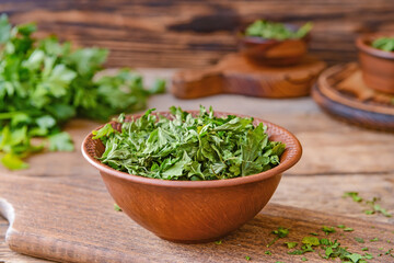 Bowl with dry parsley on table