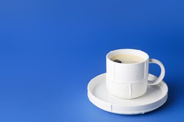 Cup of hot coffee on color background