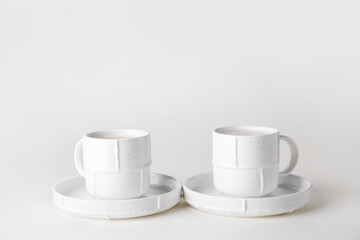 Cups of hot coffee on white background