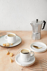 Cups of hot coffee on table