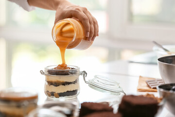 Woman preparing delicious cupcake in jar