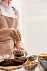 Woman preparing delicious cupcake in jar