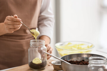 Woman preparing delicious cupcake in jar