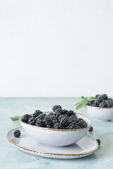 Fototapeta na wymiar Bowl with tasty blackberry on table