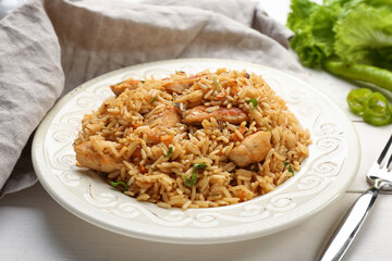 Plate with tasty pilaf on table