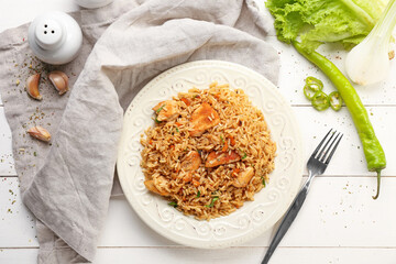 Plate with tasty pilaf on table