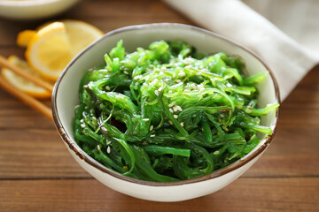 Bowl with tasty seaweed salad on table