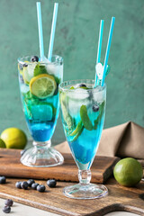 Glasses of tasty blue mojito cocktail on table