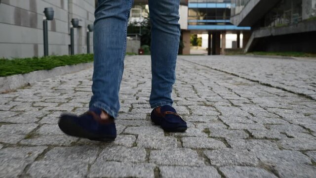 view of men's feet in moccasins walking on the cobblestones