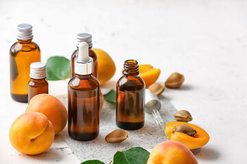 Bottles of apricot essential oil on white background