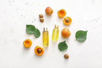 Bottles of apricot essential oil on white background