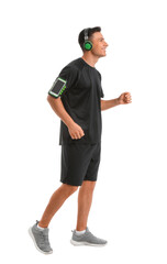 Sporty young man with headphones on white background