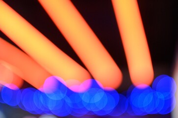 Out of focus photo of color LED and Neon lights with camera bokeh and dark background
