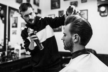 Retro styling haircut and styling. Black and white photo of a barbershop.