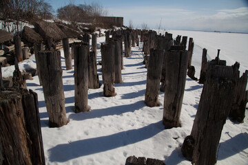 Rotten piles frozen in ice on the old pier