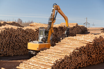Industrial loader loads logs at a sawmill