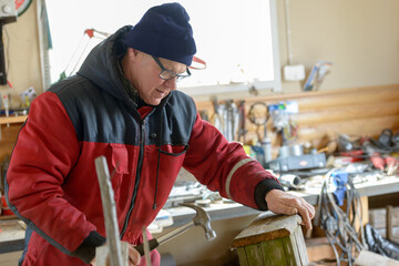 Fototapeta premium Mature handsome man making bird house indoors