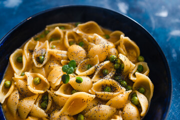 plant-based food, vegan shells pasta with pumpkin sauce and peas