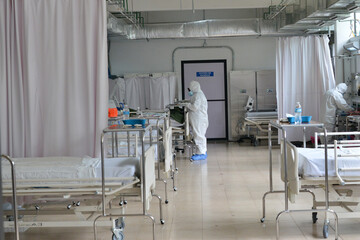 A military nurse wears Personal Protective Equipment (PPE), as a precautionary measure while treats...