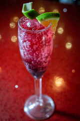 Drink Pink and red Fresh colorful exotic alcoholic cocktail with lemon and ice at the bar. Colorful pink soda with ice on the bar table. Red colored mojito