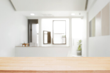Empty wooden desk space and blurry background of home window for product display montage.