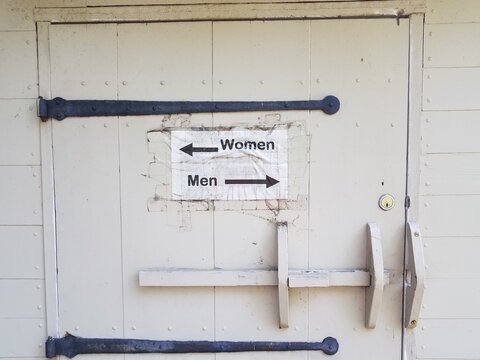 Wood Door With Men And Woman Restroom Sign And Arrows