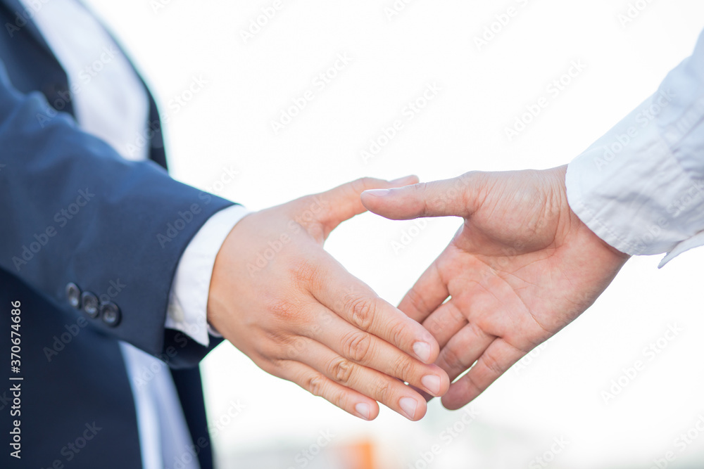 Wall mural business people shake hands to agree to a new business