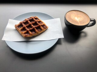 Waffle and coffee cup put on background,blurry light around