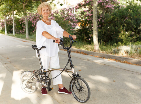 Portrait of casual senior woman going to bike at summer day